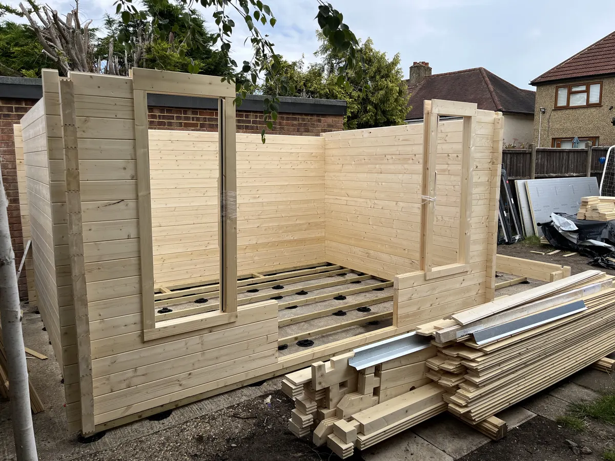 The first few rows of wall logs in place with the openings for the door and window frames