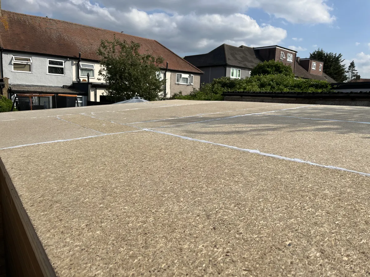Looking across the flat roof boards with their joins sealed, ready for felt